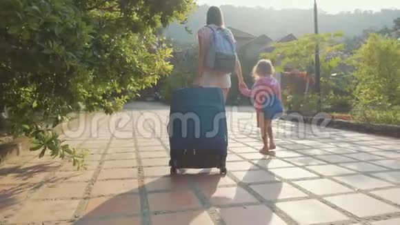 年轻的母亲带着女儿到达酒店办理入住手续携带行李视频的预览图