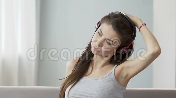 戴耳机听音乐和伸展脖子的年轻女性医疗保健视频的预览图