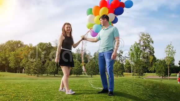 慢动作视频美丽的年轻夫妇爱玩气球和亲吻公园视频的预览图
