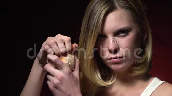 金发女郎看着相机撕开她的手柚子慢动作视频的预览图