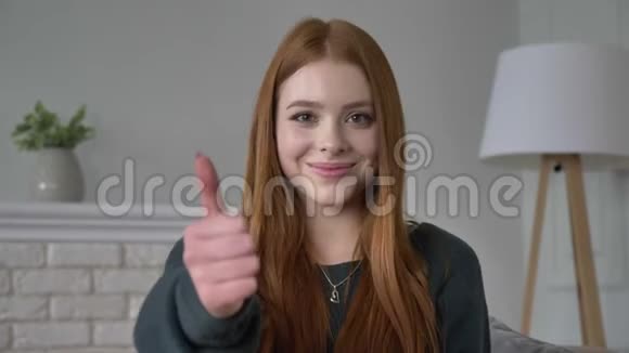 年轻的红发女孩博客作者肖像看着相机微笑显示像标志家庭舒适的背景视频的预览图