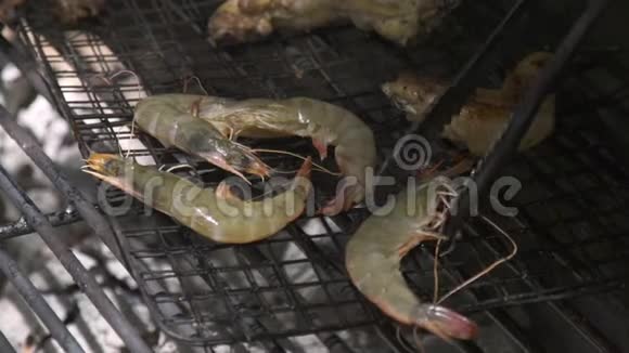 野餐的时候把虾关在烤架上火和煤烤架上的虾烤肉户外野餐海上视频的预览图