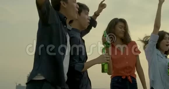 在夏季的屋顶聚会上一群年轻的朋友跳舞玩得开心一起举杯庆祝视频的预览图