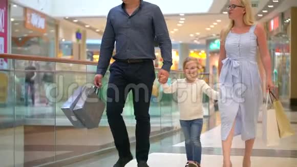 快乐的一家人在购物在商场里的家人孩子们在购物中心和父母在一起家庭购物在大商店小女孩视频的预览图