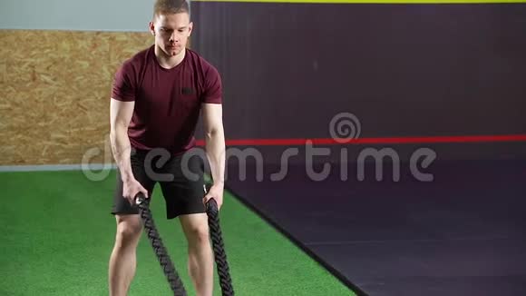 年轻的肌肉男在健身房做重绳训练视频的预览图