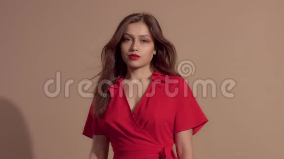 穿着米色背景红裙子的女人视频的预览图