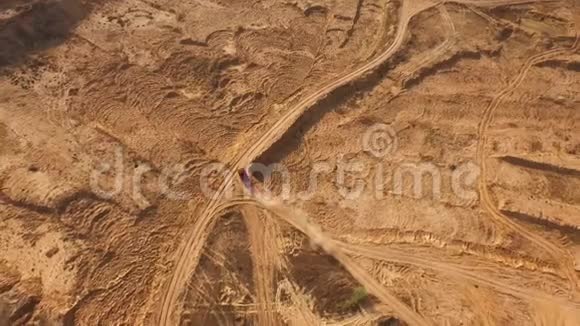 大红色卡车在沙漠的沙道上行驶的鸟瞰图沙漠之旅视频的预览图