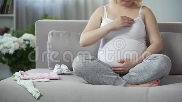 充满母性本能的女人轻轻抚摸她心爱的怀孕肚子视频的预览图