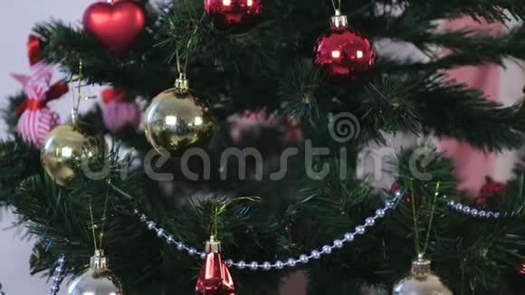 圣诞树树枝上有红色金色和银色珠子的圣诞装饰视频的预览图