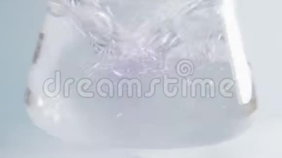 用手在实验室灯泡中摇动的透明液体变成粉红色视频的预览图