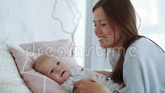 一位年轻的母亲亲吻婴儿的脸颊视频的预览图