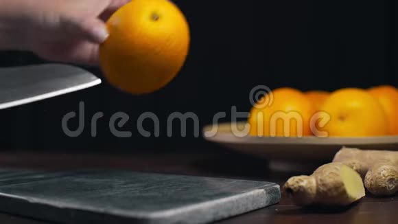 橙色是用锋利的刀切在岩石板上切片新鲜的橙色水果和维生素素食制作视频的预览图