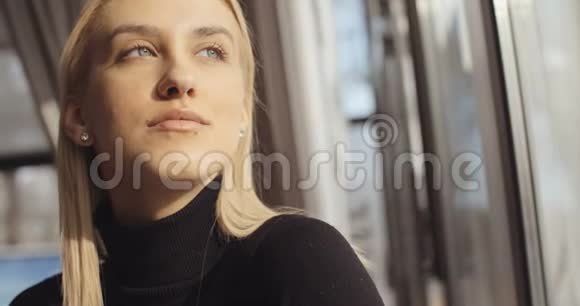 年轻沉思的女人看餐馆橱窗的肖像视频的预览图