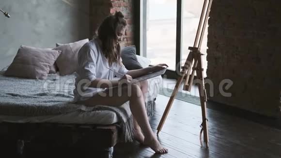 女画家在家庭工作室画了一幅画艺术家早上正在画一幅画视频的预览图
