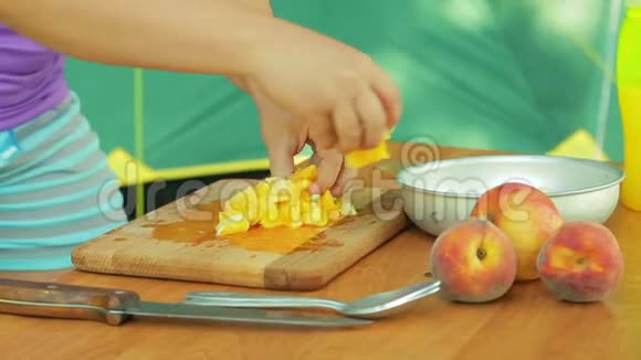 一个年轻的女人在野餐时把橘子放在碗里做水果沙拉视频的预览图