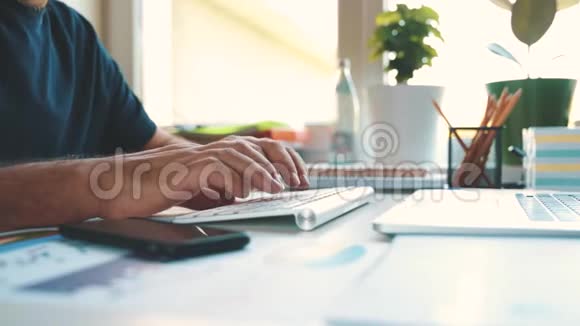 男性手在无线键盘上打字办公室里商人的工作场所视频的预览图