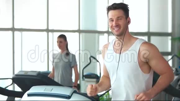 微笑的运动员在跑步机上跑步视频的预览图