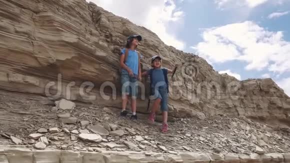 旅行者的孩子们站在悬崖边欣赏风景视频的预览图
