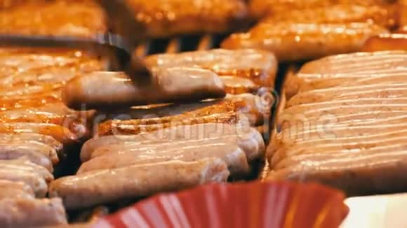 很多美味的烤纽伦堡德国香肠在圣诞节市场上连续烤女人变成油炸香肠视频的预览图