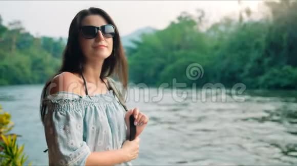 旅行的女人带着背包看着河视频的预览图