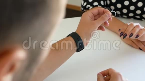 卖家在珠宝店给女孩一枚戒指女人看着她手指上的戒指在珠宝店女士视频的预览图