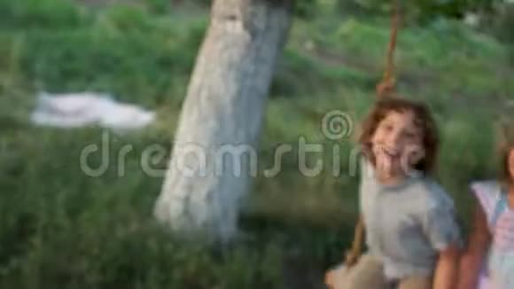村里树上的秋千两个孩子滑冰笑暑假乡村假日视频的预览图