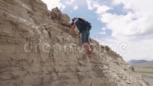 孩子爬上小山带背包的小女孩旅行者视频的预览图