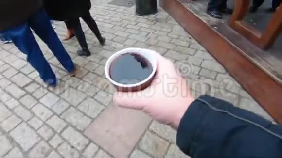 在市场上拿着一杯覆盖的葡萄酒的人视频的预览图