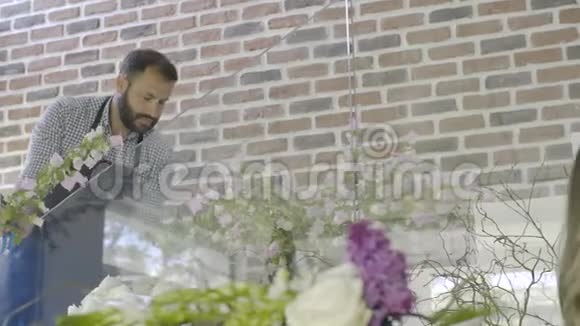 花商从他的店里挑选花并检查花的排列视频的预览图
