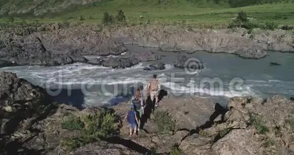 空中飞行旅行者接近山河附近的悬崖边缘空中观景有孩子的旅行家视频的预览图