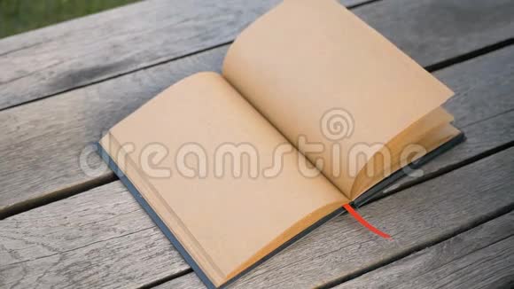 女的手缓缓翻开一页干净的书一本米色的笔记本手指上的环视频的预览图