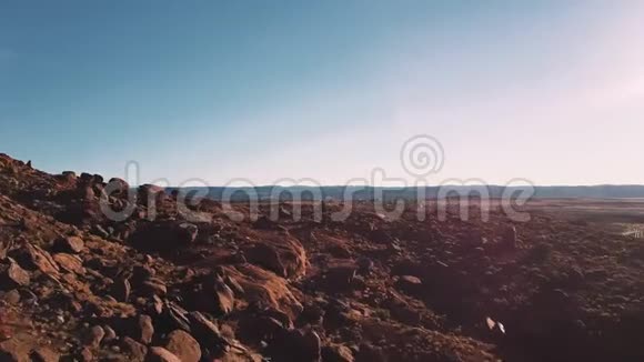 在美国亚利桑那州的日落中无人机低空飞行美国砂岩景观覆盖着岩石和石头视频的预览图