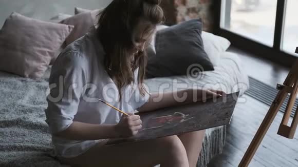 女画家在家庭工作室画了一幅画艺术家早上正在画一幅画视频的预览图