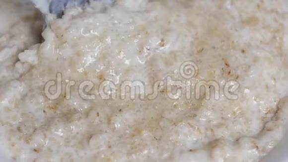 烹饪燕麦片用勺子搅拌燕麦片特写早餐视频的预览图