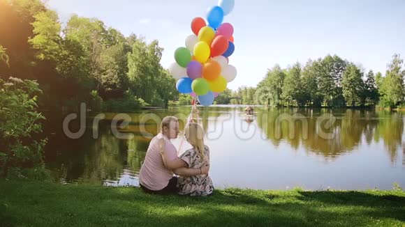 慢镜头视频美丽浪漫的情侣相爱抱着一大堆气球拥抱是湖视频的预览图
