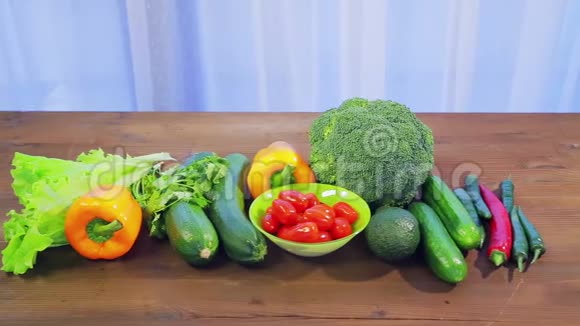木桌上摆着新鲜蔬菜西葫芦西兰花生菜鳄梨黄瓜胡椒和辣椒视频的预览图