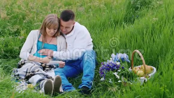 一位孕妇和她的丈夫看着他们未来孩子的超声波照片视频的预览图