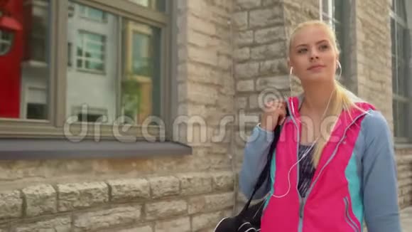 年轻有魅力和运动的金发女孩带着一个运动包在户外散步保健健身和生活方式视频的预览图