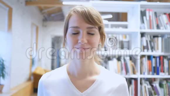 微笑的年轻女子戴着耳机听音乐视频的预览图