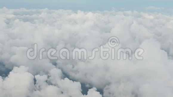 从蓝天的飞机窗口俯瞰云层上空的4K鸟瞰图视频的预览图