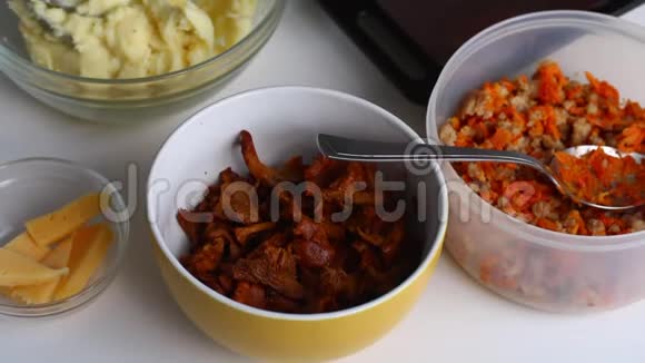 桌子上有配料蘑菇土豆泥和胡萝卜碎肉视频的预览图