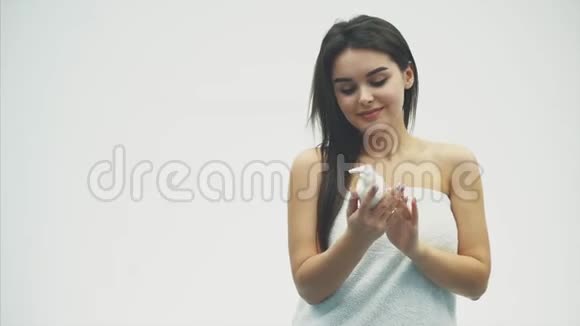 一位美丽的年轻女孩的特写镜头上面涂着奶油乳液这与她的肩膀有关为她感到快乐和快乐视频的预览图