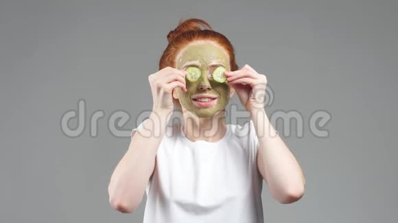 迷人的红发女孩用白底黄瓜遮住眼睛视频的预览图