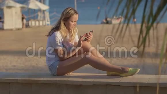 夏天海滩上带手机的女孩在海上旅行视频的预览图