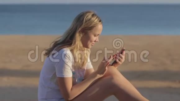 夏天海滩上带手机的女孩在海上旅行视频的预览图