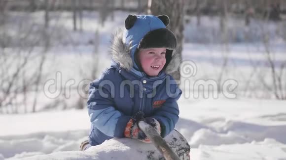 一个小孩在冬季公园里玩耍笑嘻嘻的晴朗的霜天新鲜空气中的乐趣和游戏视频的预览图