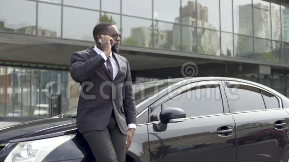 在大城市里一个严肃的富人穿着昂贵的商务服在电话中交谈视频的预览图