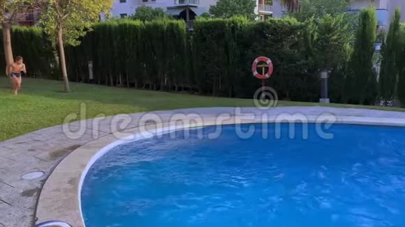 小孩跳进游泳池的蓝水里视频的预览图