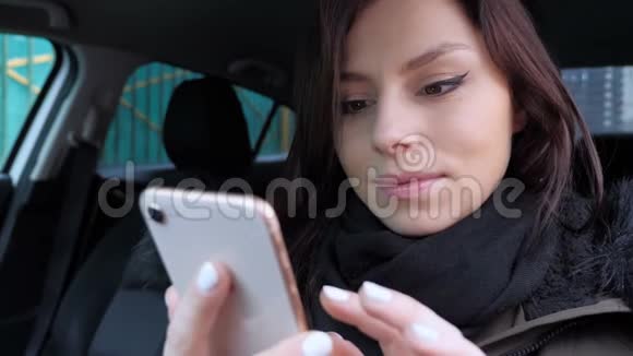 女人在使用电话时为成功而兴奋坐在车里视频的预览图