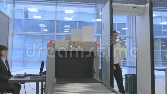 英俊的商人在机场用x光扫描仪检查行李视频的预览图